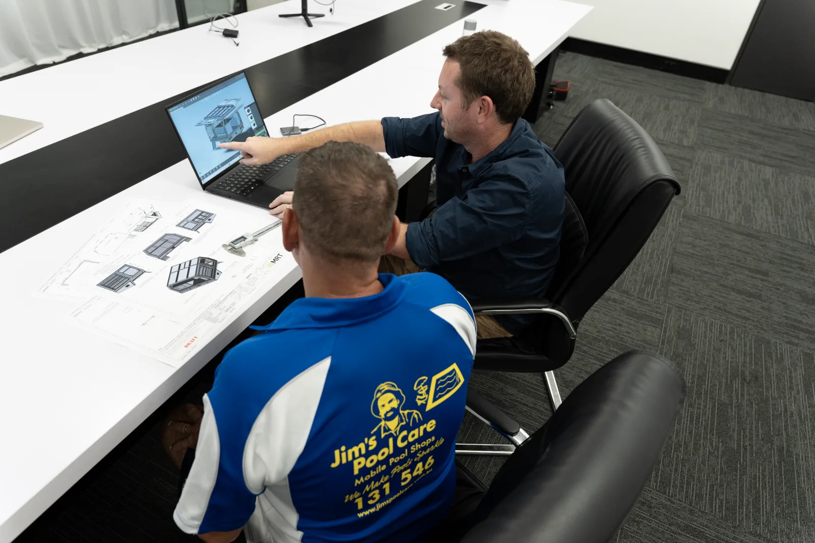 MRT fleet specialists reviewing a canopy build plan on a laptop with a fleet customer